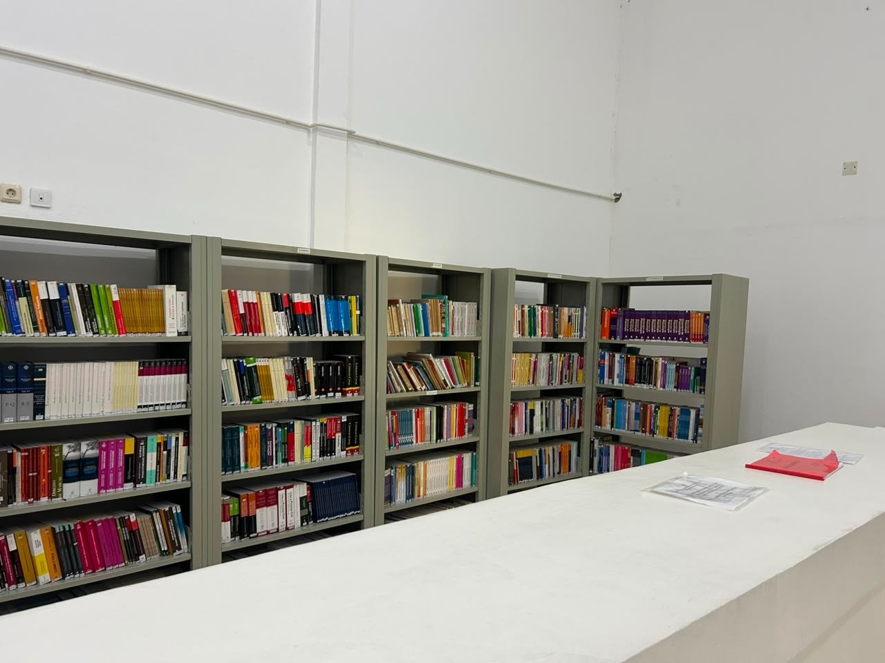 Acervo académico organizado nas estantes da biblioteca do ISPRL