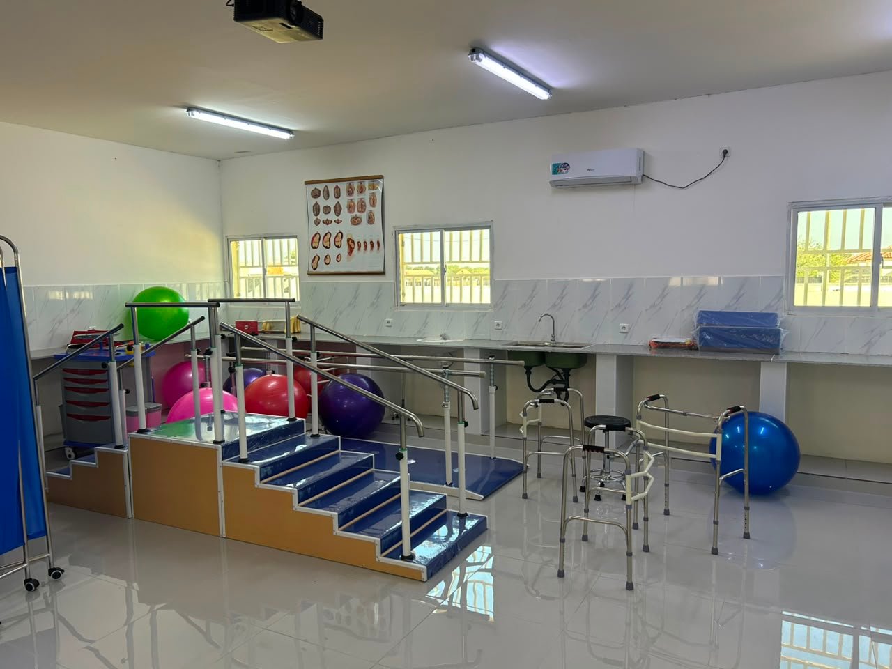 Sala de fisioterapia do ISPRL com barras paralelas, escada de reabilitação e bolas terapêuticas