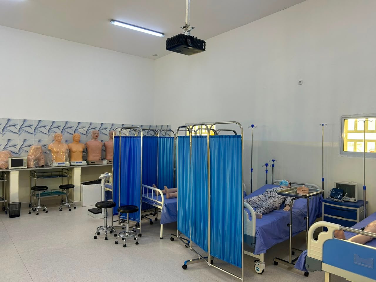 Laboratório de simulação clínica do ISPRL com manequins de enfermagem e biombos